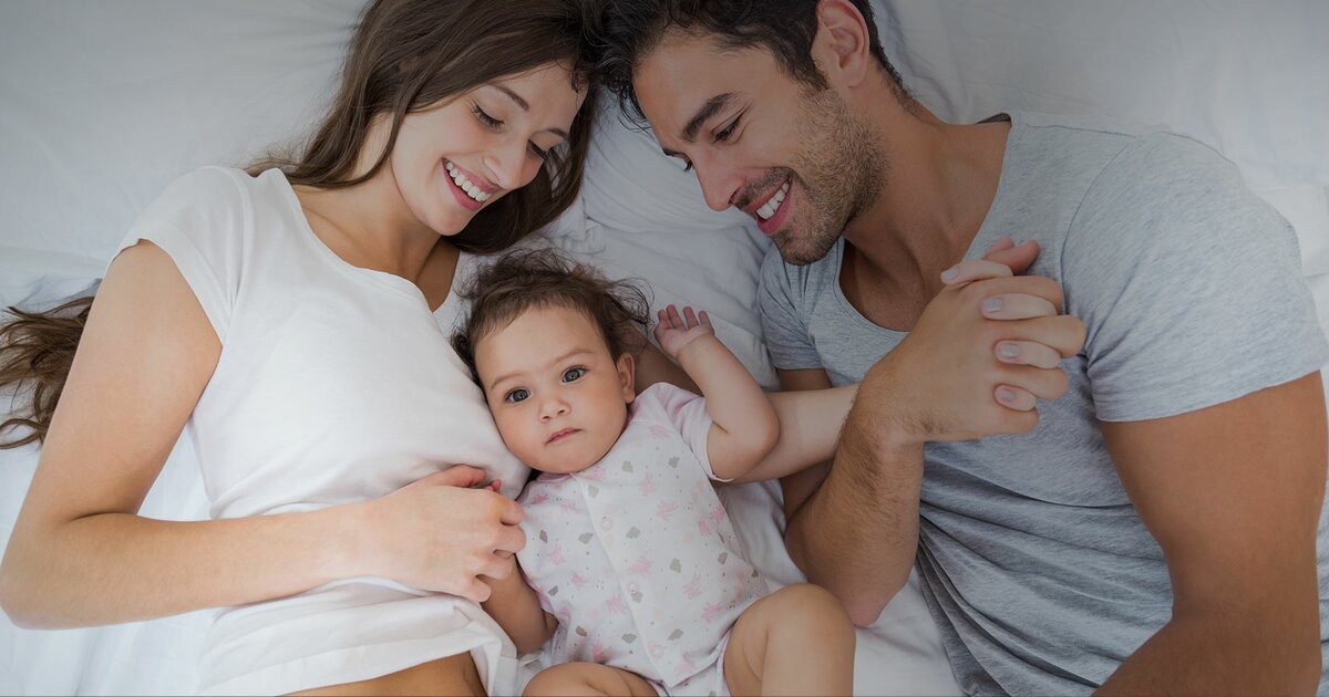 baby sleeping in bed with parents
