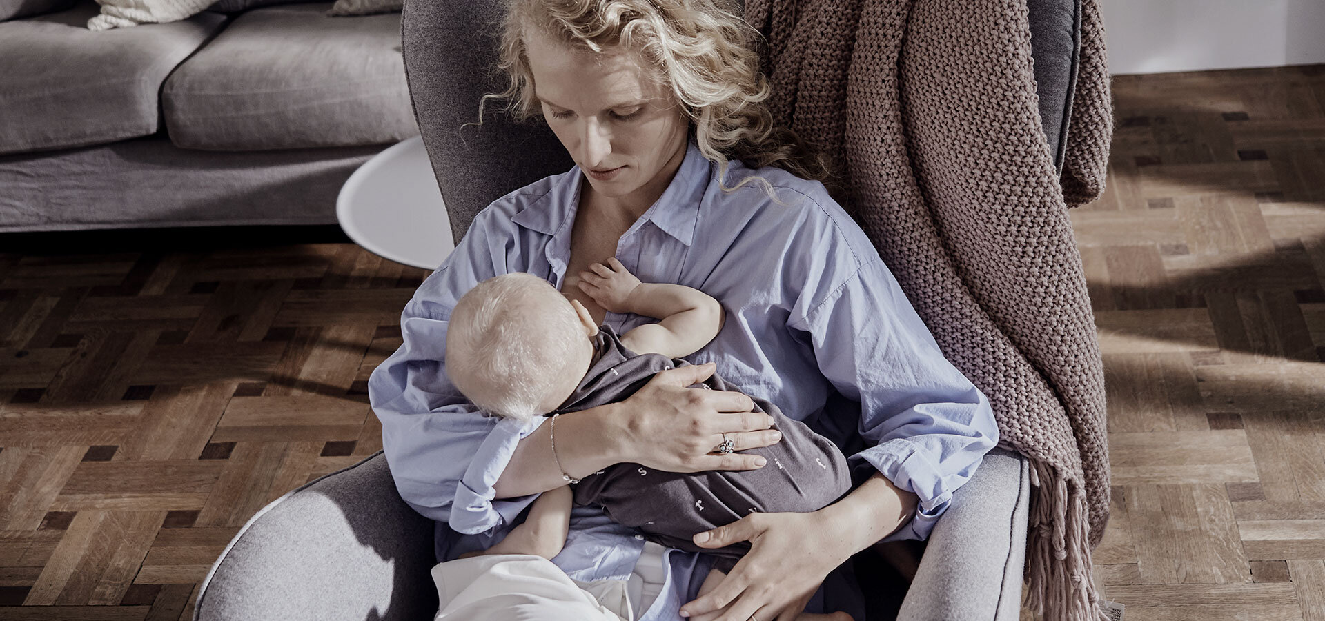 The woman is breastfeeding her baby boy