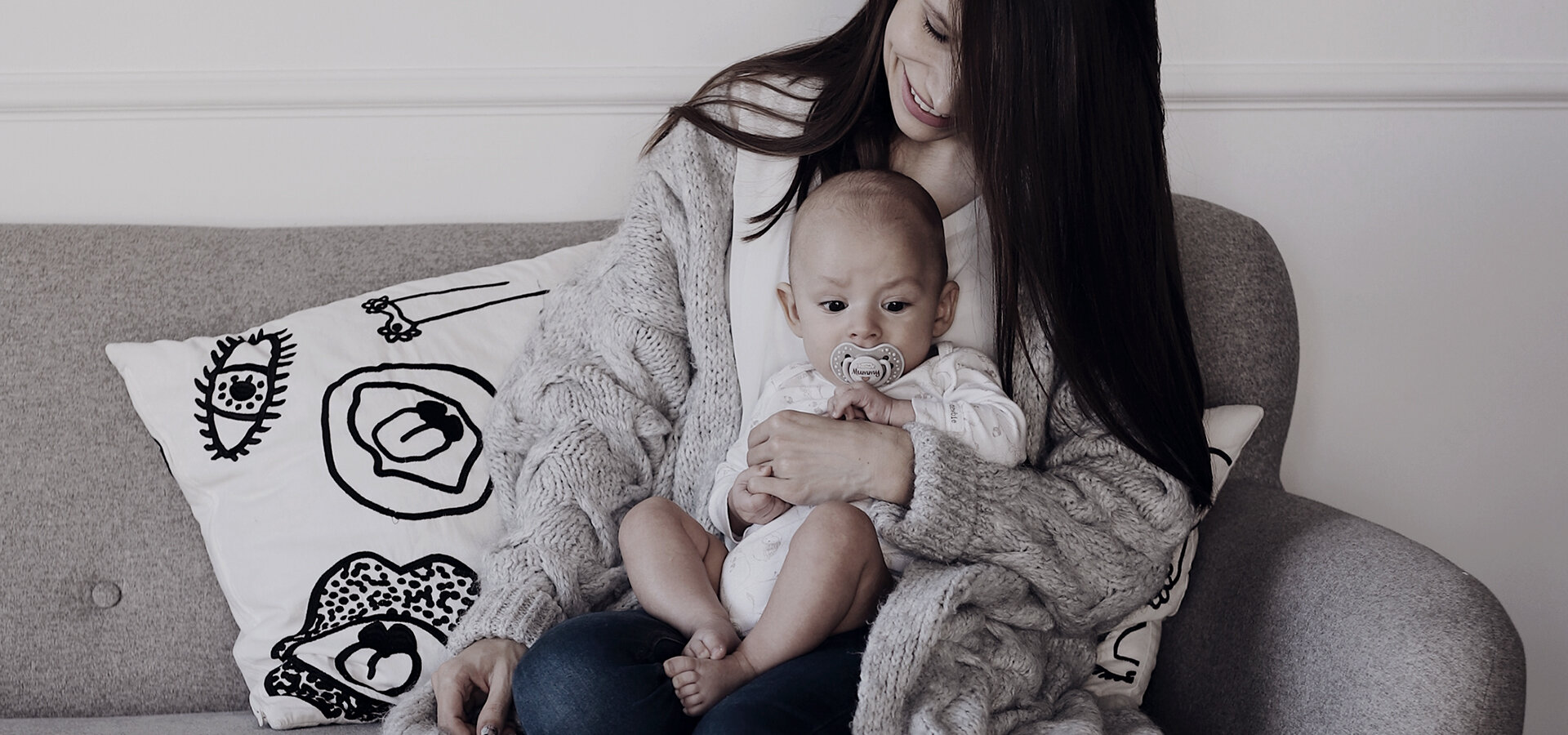 Молодая мать сидит и держит ребенка на коленях